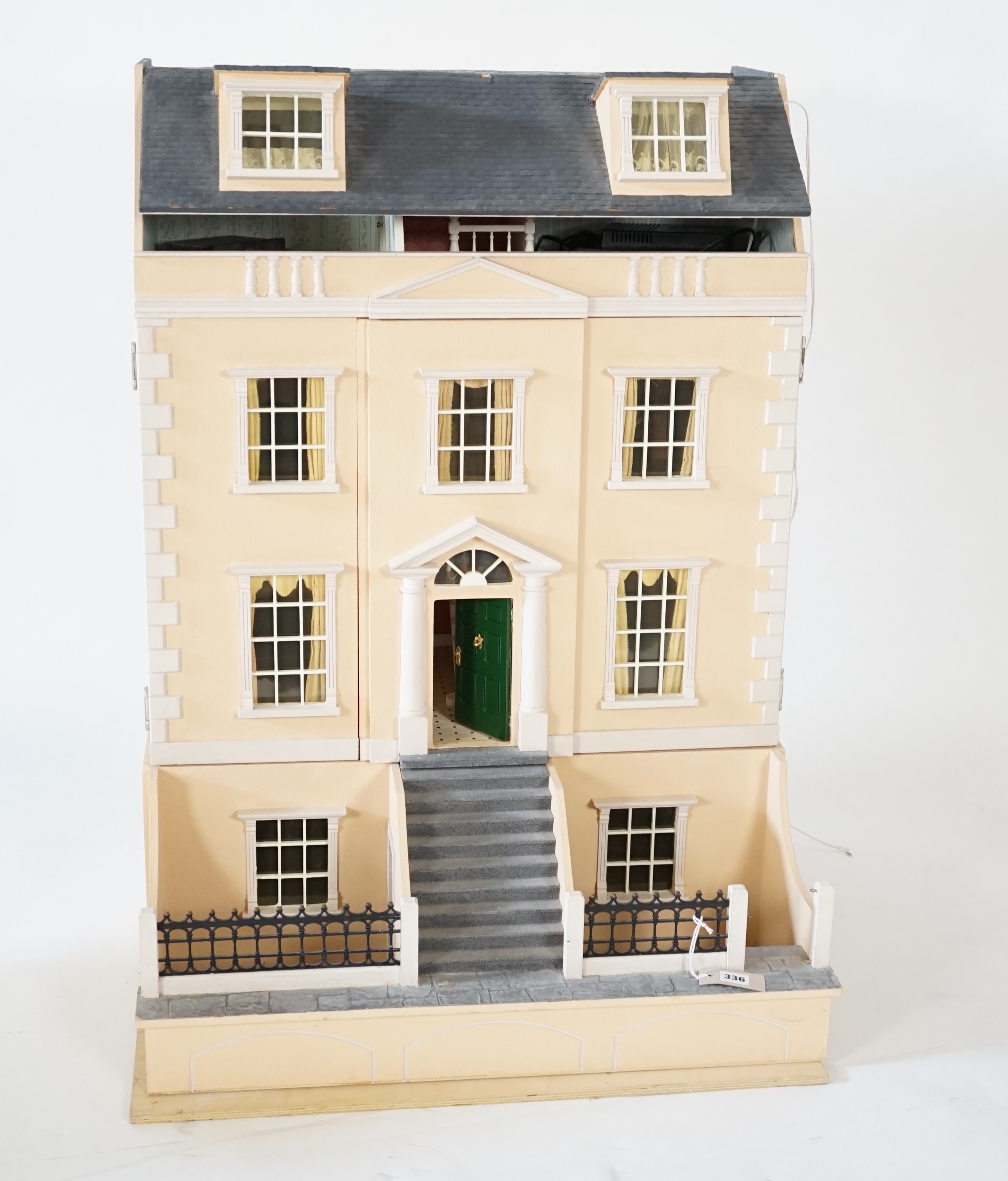 A large modern Georgian style dolls house and extensive contents, with eight fully decorated rooms on four floors, and fitted with electric lighting, removable front steps and pavement section to access basement rooms, 1